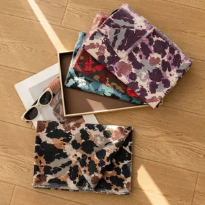 Elegant vintage leopard print and tie-dye long scarves collection displayed on wooden floor