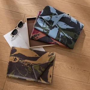 Korean style abstract print wool blend scarf displayed on a wooden floor with props