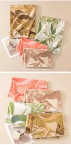 Detailed view of autumn/winter scarves with elegant floral patterns in warm neutral colors.