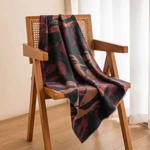 Elegant abstract pattern wool blend shawl scarf for winter warmth draped over wooden chair