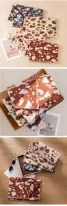 Close-up detail of soft leopard print scarves in various autumn colors and patterns.