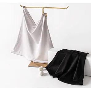 Detailed view of grey and black knit silk neck gaiters on professional display stand