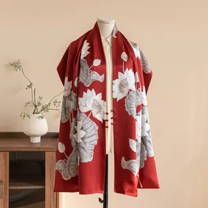 Detailed view of a red silk shawl featuring a white lotus print and Chinese buttons