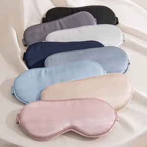 Masques de sommeil en soie douce de plusieurs couleurs sur un fond de tissu neutre