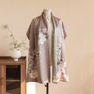 Detailed view of an elegant floral silk shawl with Chinese-style buckles on a mannequin