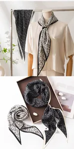 Close-up display of elegant paisley patterns on monochrome silk scarves for women.