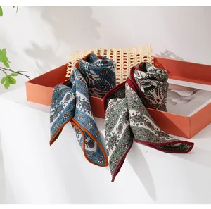 Detailopname van elegante zijden wollen sjaals met paisley bloemenprint in geschenkdoos