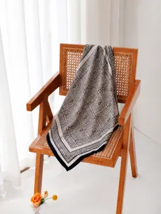 Dettaglio di un foulard quadrato in seta e lana con stampa paisley vintage su una sedia