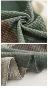 Close-up detail of soft green and grey woven imitation cashmere scarf fabric texture