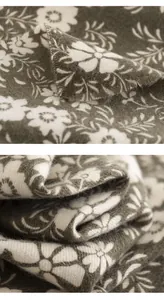 Close-up of soft daisy print fabric with delicate fringe detail on a winter scarf.