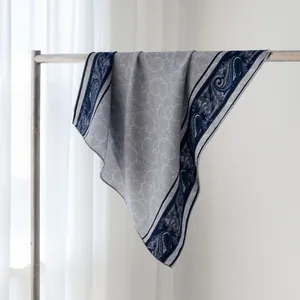 Vue détaillée d'un foulard en laine et soie à motif paisley avec bords roulés main