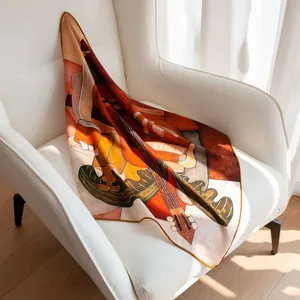 Foulard carré artistique en laine et soie sur un fauteuil blanc moderne