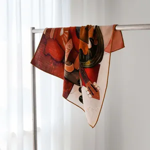 Gros plan d'un foulard en soie et laine vintage avec imprimé guitare abstrait et bords roulottés.