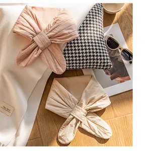 Detail view of quilted silk-filled triangle scarves in soft pink and beige colors