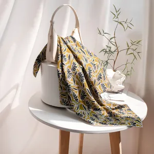 Détail d'une écharpe en laine et soie avec imprimé floral vintage et bords roulés