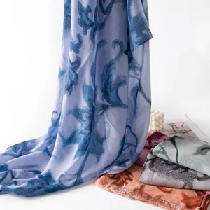 Detailed view of lightweight oversized scarves with vintage paisley patterns and frayed edges