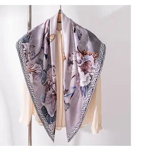 Detailansicht eines eleganten quadratischen Schals mit Blumen- und Schmetterlingsdruck.