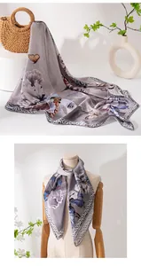 Eleganter lila Seidenschal mit Blumen- und Schmetterlingsprint, drapiert auf Schneiderpuppe.