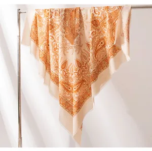 Detailansicht eines luxuriösen Seidenwollschals mit orangefarbenem Paisleymuster und Fransen