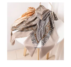 Nahaufnahme eines eleganten Seiden-Woll-Schals mit Paisleymuster und feinen Fransen
