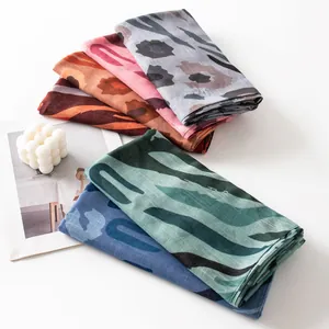 Detailed close-up of multi-colored animal print scarves folded neatly with stylish props