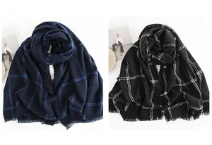 Detailed view of two checkered scarves in navy blue and black with soft fringe edges