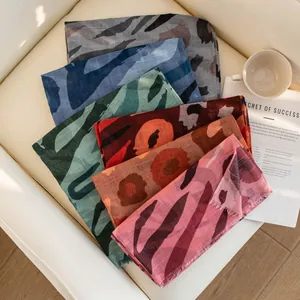 Macro view of colorful thin ethnic animal print scarves stacked elegantly on a chair