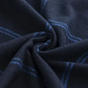 Macro detail of a soft blue plaid scarf showing high-quality stitching and fabric texture.