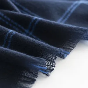 Detailed close-up of a soft blue checkered scarf for men with elegant fringed edges