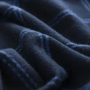 Macro detail of the soft blue and black checkered fabric texture on a men's winter scarf