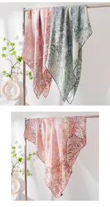Vista detallada del elegante chal de seda de morera con estampado floral en un soporte
