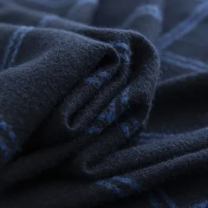 Macro view of soft texture and blue plaid pattern on men's winter scarf