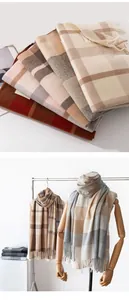 Detailed view of soft imitation cashmere plaid scarves with tassels in neutral tones
