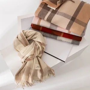 Stack of multicolored plaid imitation cashmere scarves with soft fringe details.