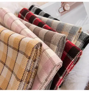 Detailed view of various thick plaid scarves in autumn colors and soft textures for winter