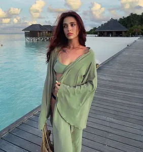 Elegant sage green long-sleeved beach cover-up cardigan for women at a tropical resort