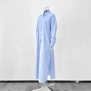 Full-length light blue long sleeve shirt dress with side slits on a clear mannequin