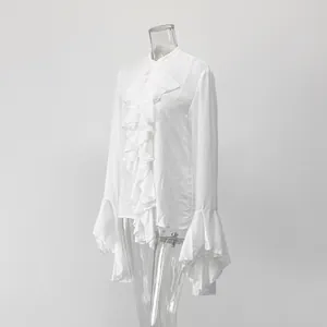 Detalle de una elegante blusa blanca con volantes, puños acampanados y cuello tipo mao