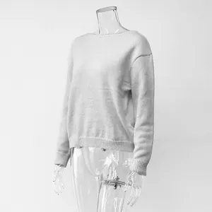 Detailed side view of a minimalist white long-sleeve knit sweater on a mannequin