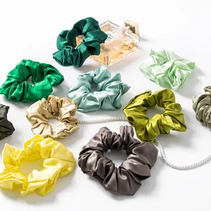 Collection of premium silk scrunchies in varied colors with elegant pearl detail