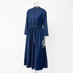 Side view of navy blue long denim dress featuring stand collar and self-tie belted waist