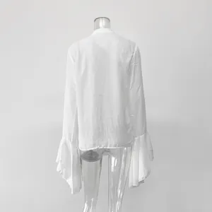 Vista posterior de una camisa blanca de manga larga con elegantes volantes en los puños.