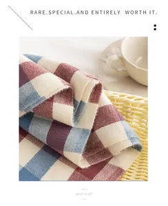 Detailopname van een zachte wollen sjaal met een rood en blauw ruitpatroon in setting