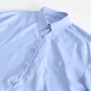 Close-up detail of light blue French-style shirt dress with collar and front pocket