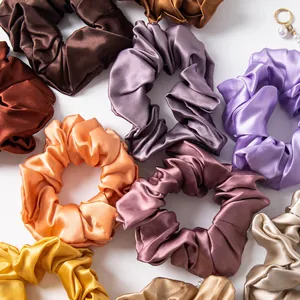 Detailed shot of various solid colored large satin scrunchies with elegant silk sheen