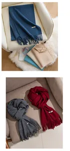 Close-up of assorted solid color faux cashmere scarves with elegant tassels on armchairs