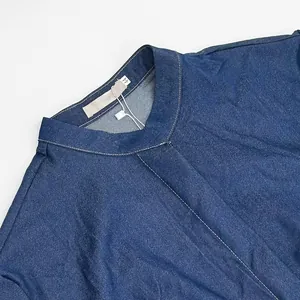 Close-up view of the stylish mandarin collar and contrast stitching on a navy denim dress