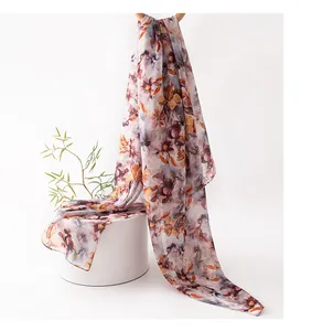 Vista dettagliata di un foulard in seta di lusso con stampa floreale su un piedistallo.