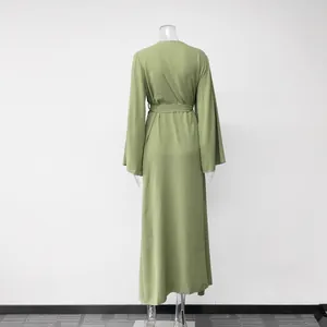 Back view of an elegant long green wrap dress featuring flared sleeves and waist tie