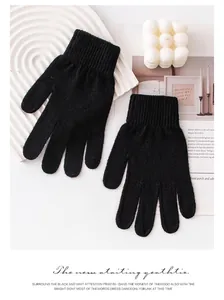 Dettaglio macro di guanti in maglia di cashmere nero su sfondo bianco minimalista